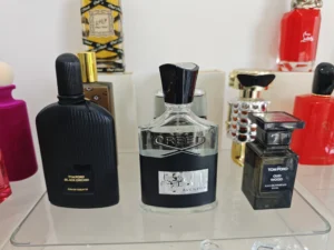 A side-by-side comparison of a $300 luxury designer perfume bottle and a high-quality clone fragrance alternative.