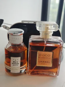 Side-by-side visual comparison of a traditional luxury designer perfume bottle and an affordable factory-direct alternative fragrance on a vanity