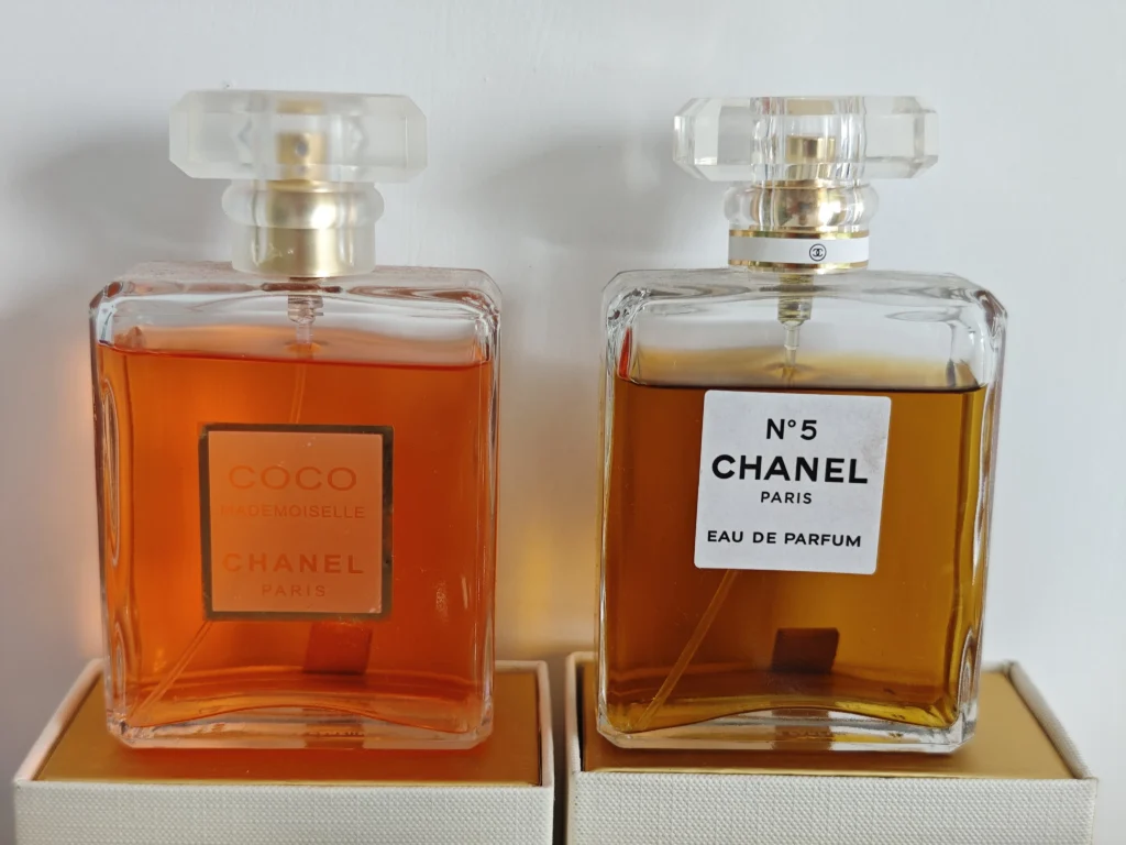 Side-by-side comparison of a luxury designer perfume bottle and a high-quality Coco Mademoiselle dupe from an independent lab, illustrating the difference in packaging costs.