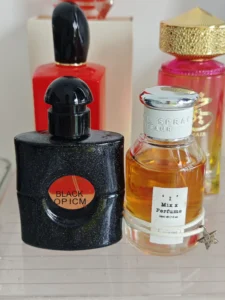 How to Find the Best YSL Black Opium Parfum Dupe (And Secret Hacks to Make It Last All Day) 2 Side-by-side comparison of a YSL Black Opium designer perfume bottle and a high-quality affordable alternative showcasing the coffee vanilla fragrance notes.