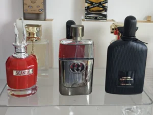 Close-up shot comparing high-quality alternative perfume liquid with an expensive luxury brand fragrance bottle, highlighting the premium atomizer and clarity of the juice.