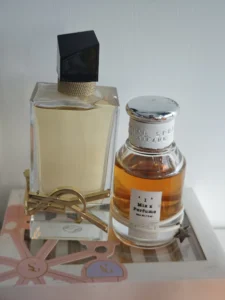 Comparison chart showing the golden liquid of a luxury floral-fougère fragrance next to an affordable, high-concentration perfume dupe.