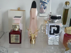 A side-by-side comparison of a luxury designer perfume bottle and a minimalist direct-to-consumer alternative fragrance bottle showcasing the differences in packaging design.
