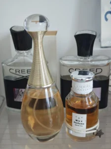 A bottle of IMIXX No. 42 Eau de Parfum placed next to a luxury gold floral fragrance, demonstrating the value of direct-to-consumer perfume dupes in the USA.